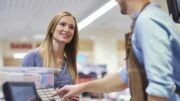 Woman next to cash register talking with sales clerk