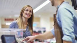 Woman next to cash register talking with sales clerk
